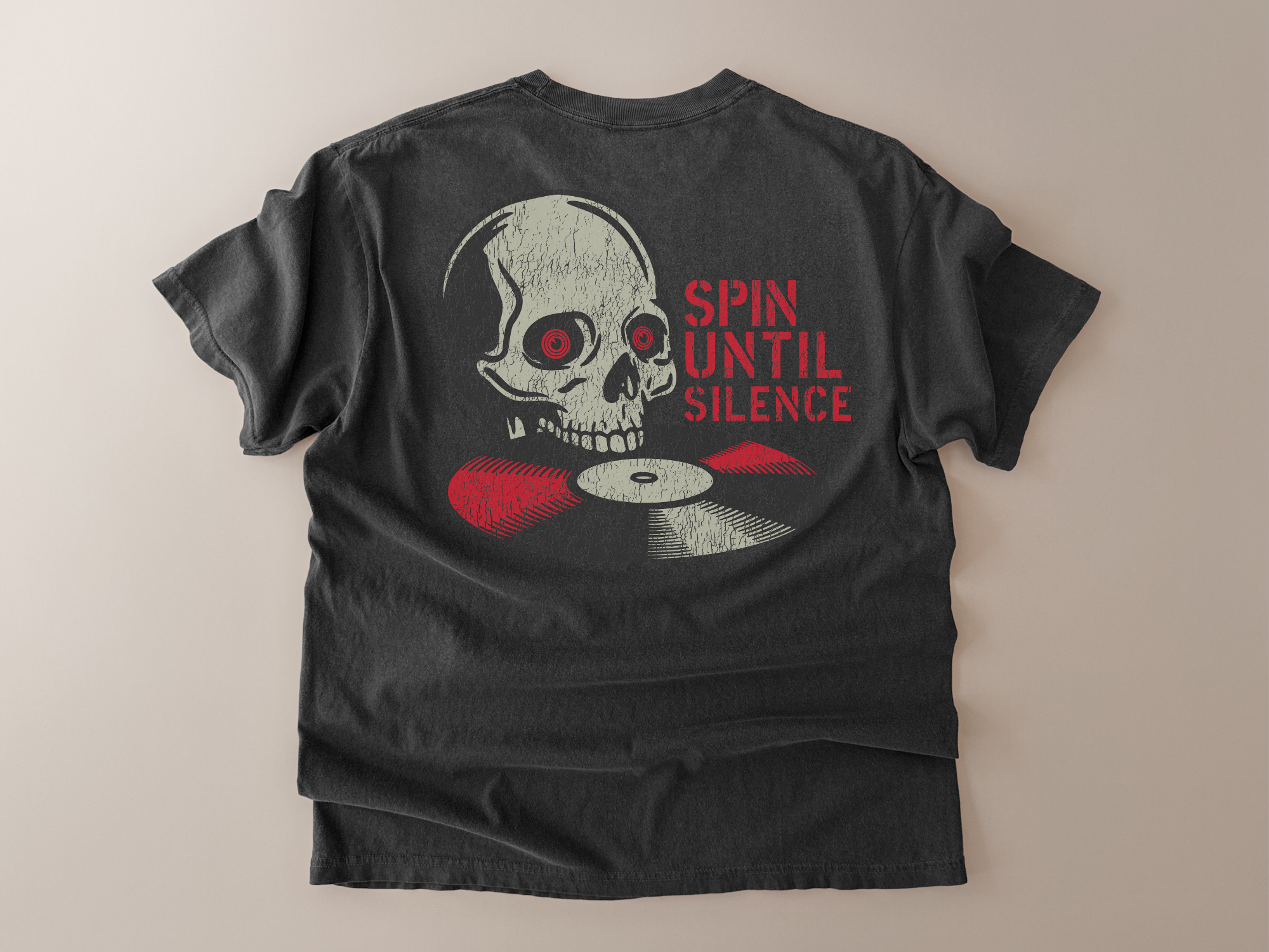Black t-shirt with a skull and vinyl record design on the back, on a beige background