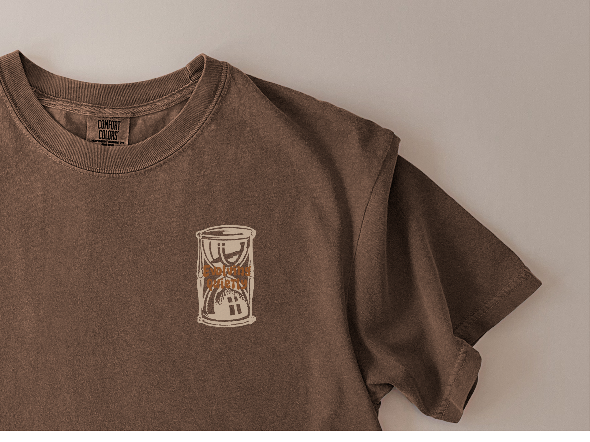 Brown t-shirt with a small graphic on a plain background