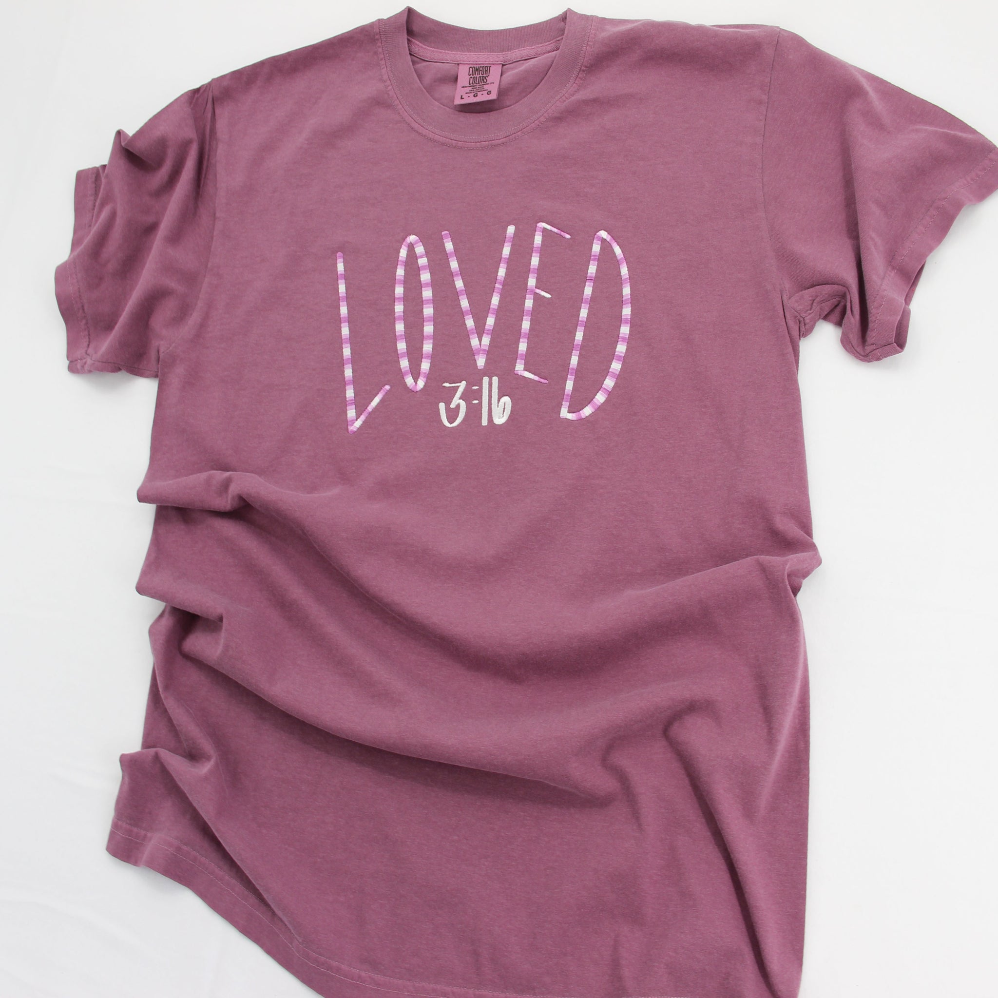 Purple t-shirt with 'LOVED' text on a white background