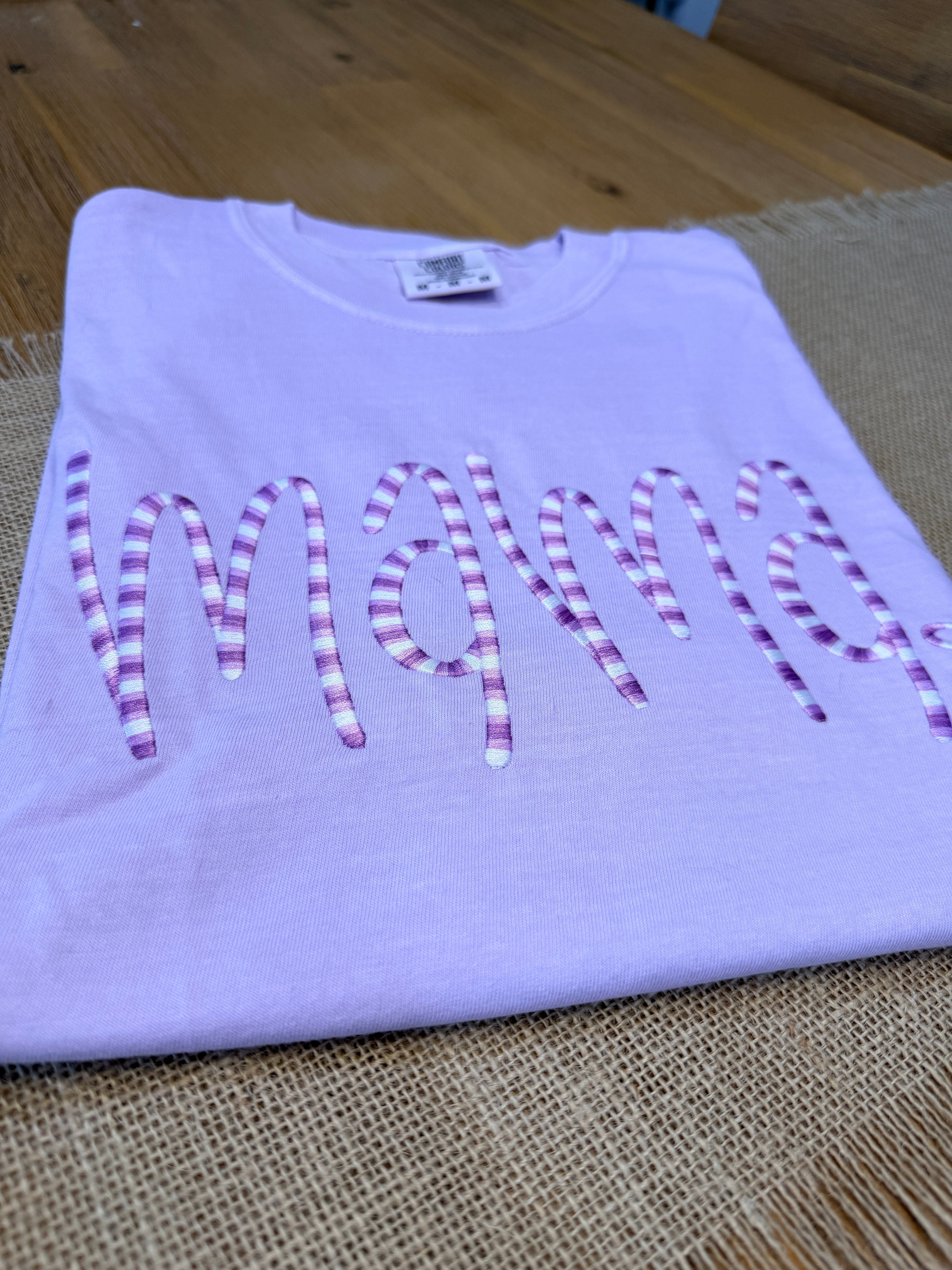 Purple shirt with decorative text on a textured surface