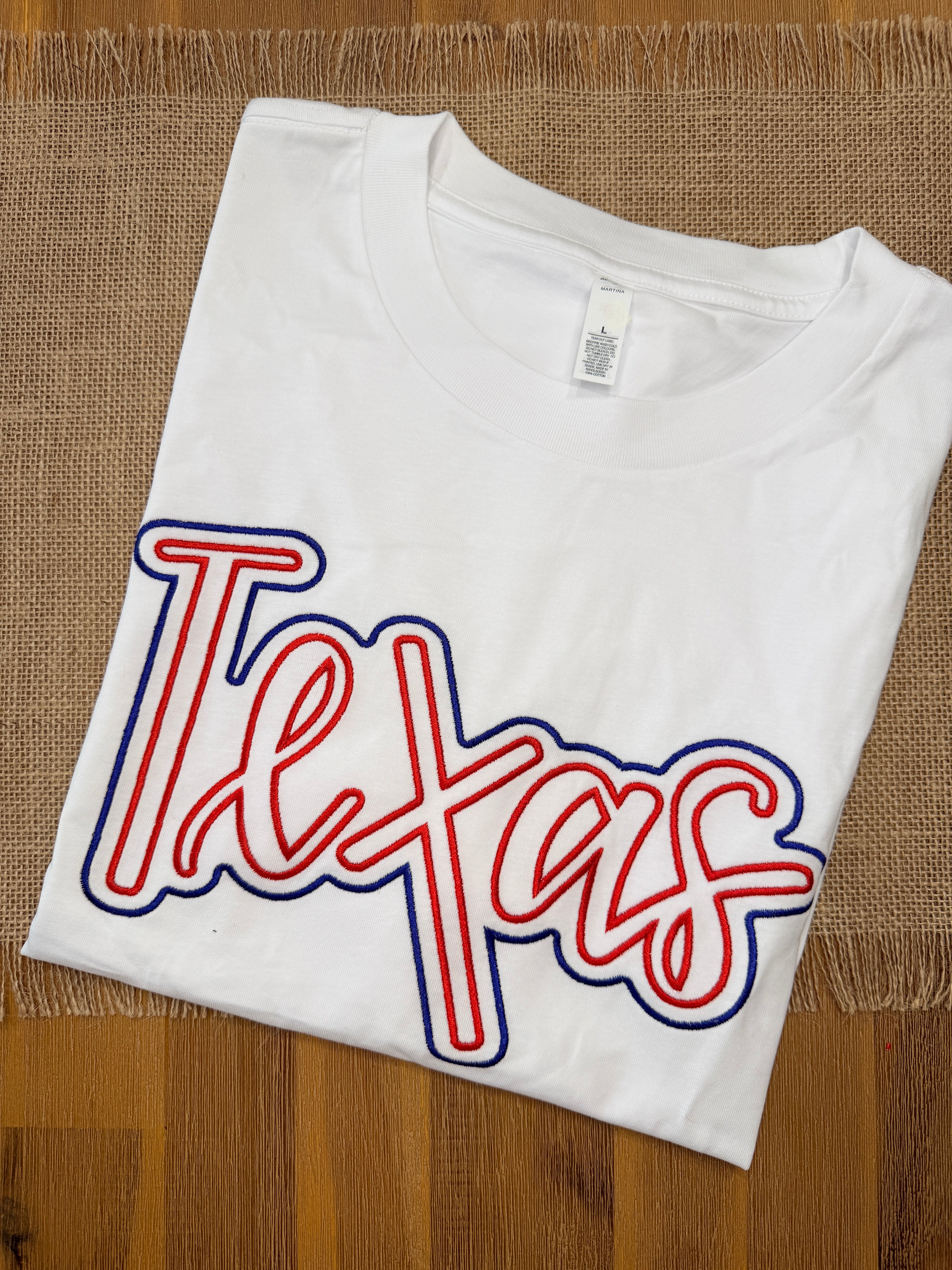White tank top with red and blue 'Lexicon' logo on a wooden surface