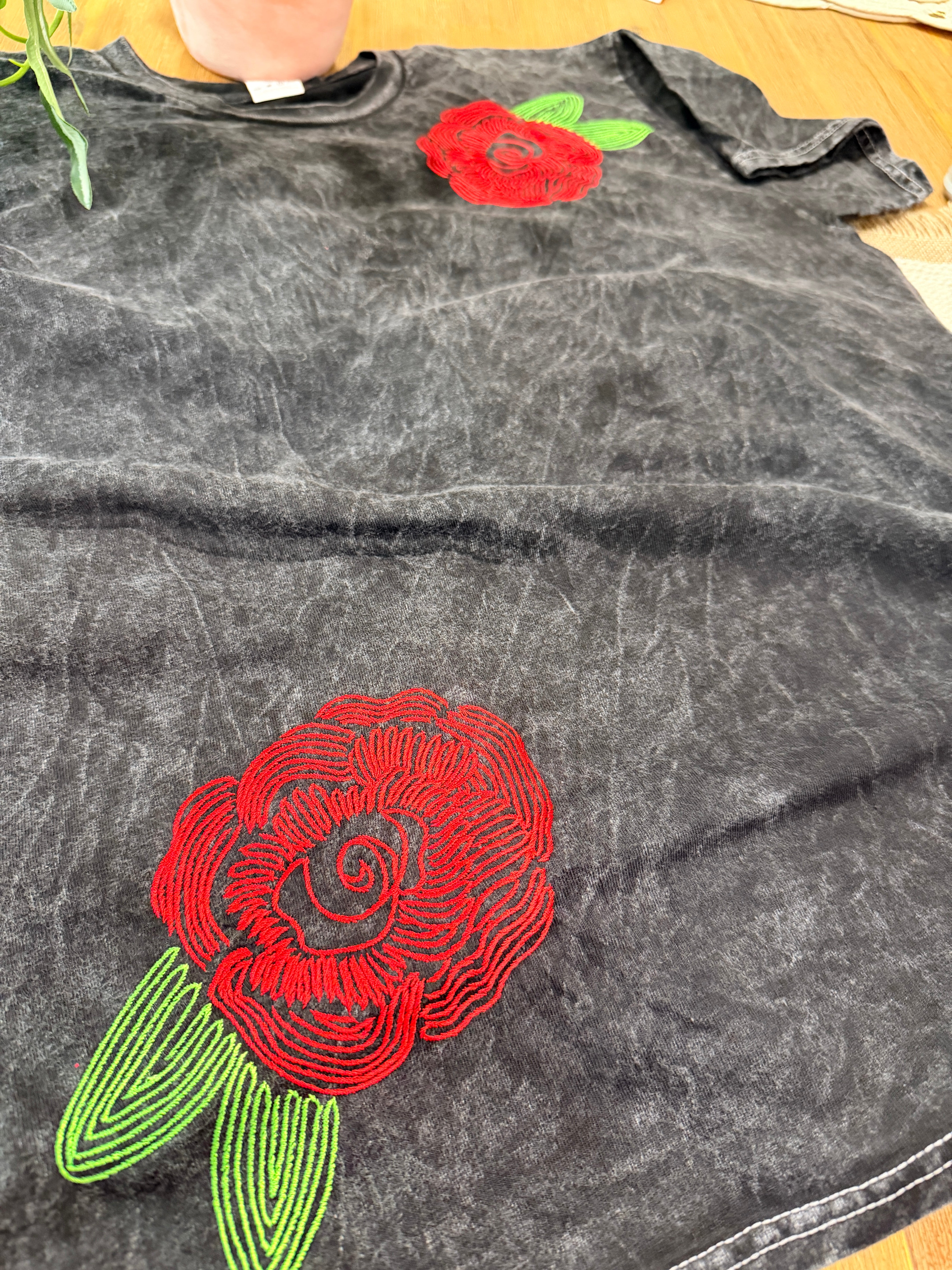 A washed black canvas with story stitched into every detail. The Midnight Bloom Tour Tee is designed to feel like something collected over time—soft, worn, and quietly striking. Three thoughtfully placed embroidery moments create movement across the garment, giving it that imperfect, artful balance that feels both elevated and undone.