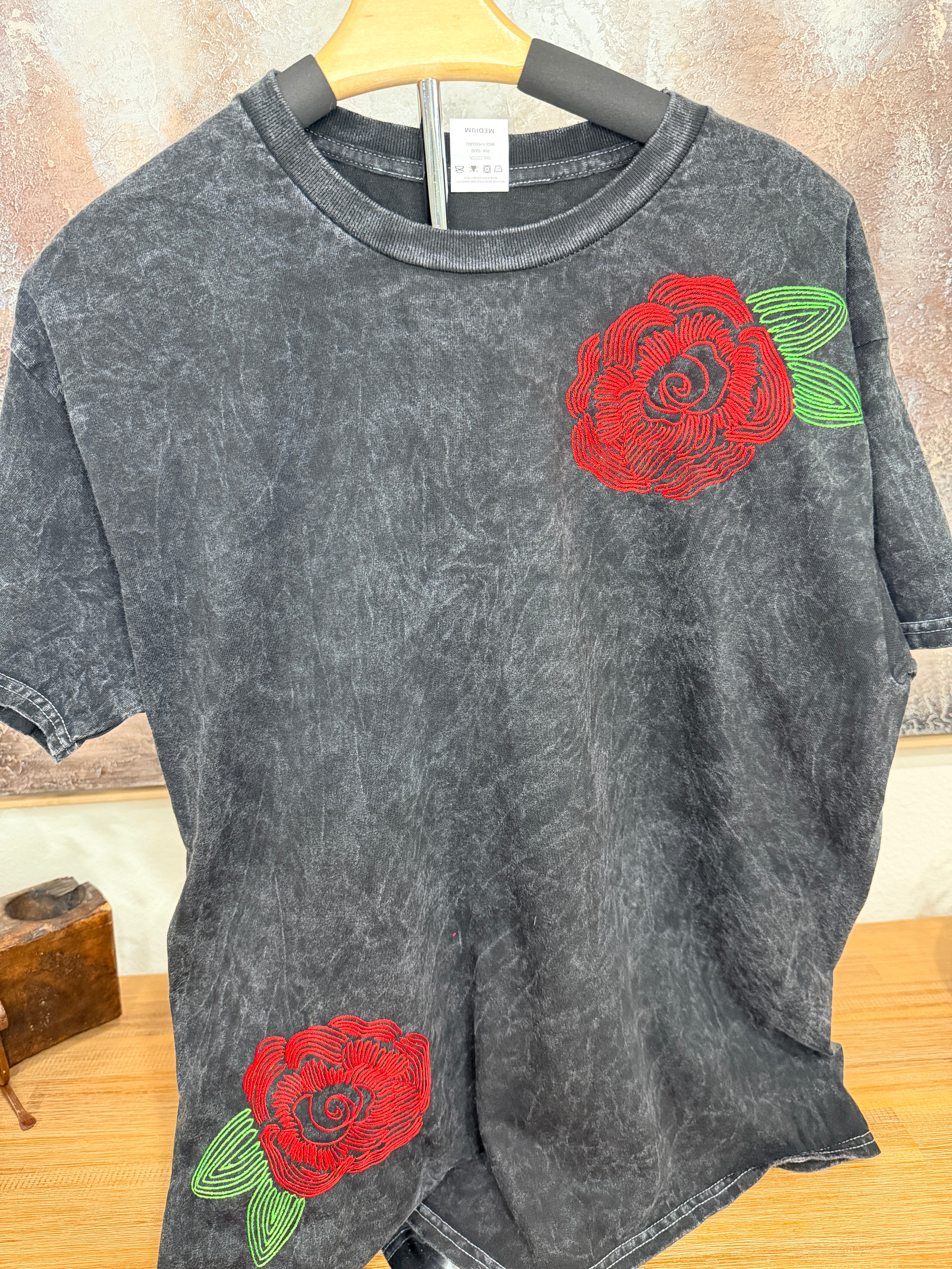 A washed black canvas with story stitched into every detail. The Midnight Bloom Tour Tee is designed to feel like something collected over time—soft, worn, and quietly striking. Three thoughtfully placed embroidery moments create movement across the garment, giving it that imperfect, artful balance that feels both elevated and undone.
