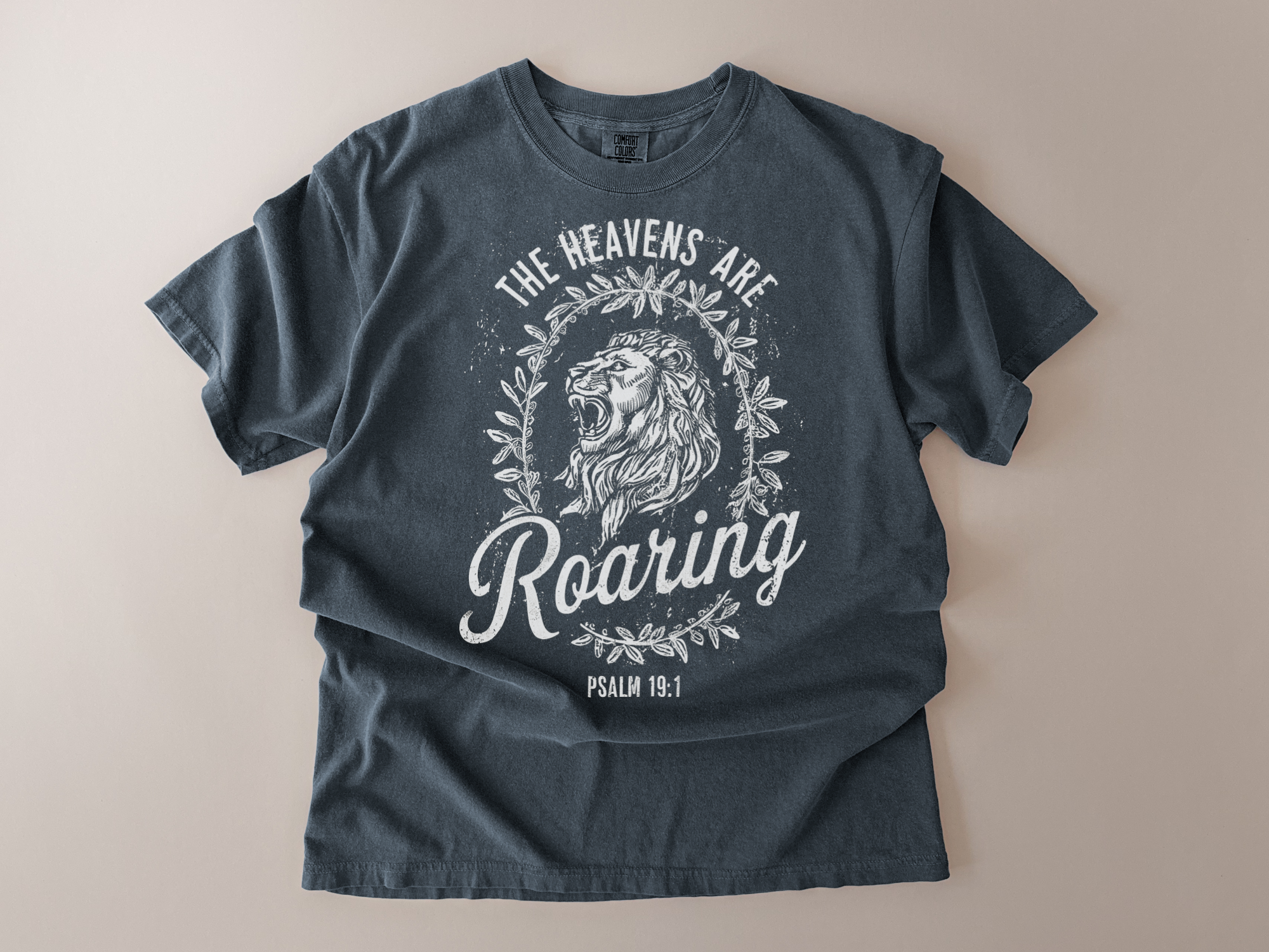 Blue t-shirt with a lion graphic and text on a beige background