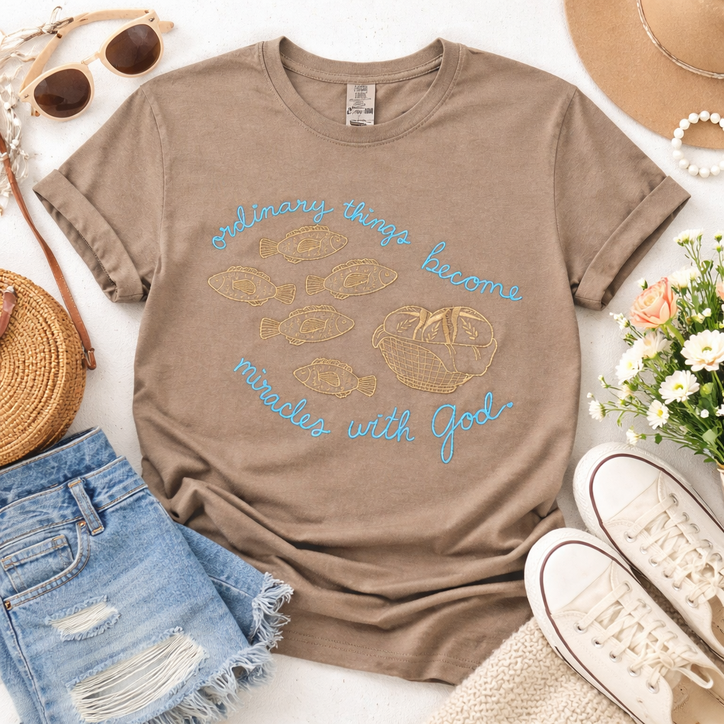 Brown t-shirt with motivational quote, sunglasses, denim shorts, sneakers, and flowers on a white background