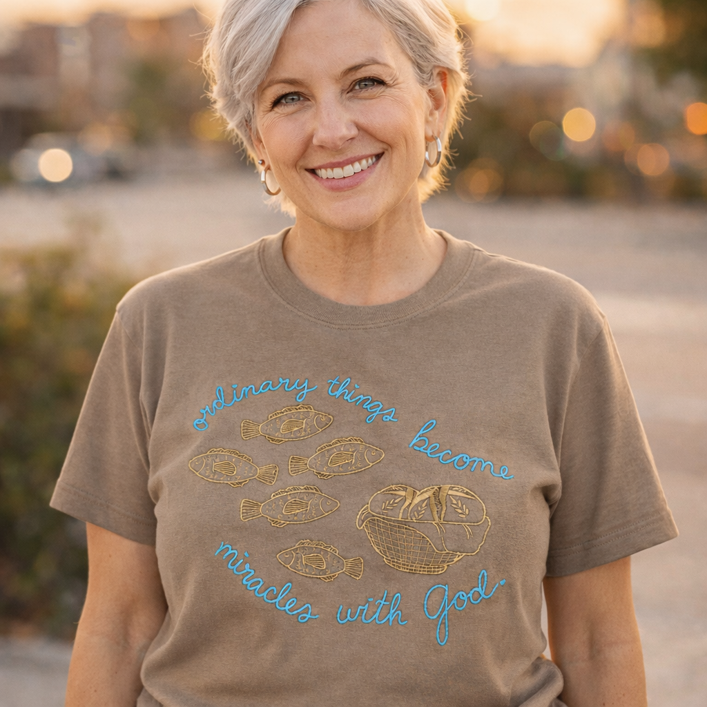 Woman wearing a brown t-shirt with a motivational quote outdoors.