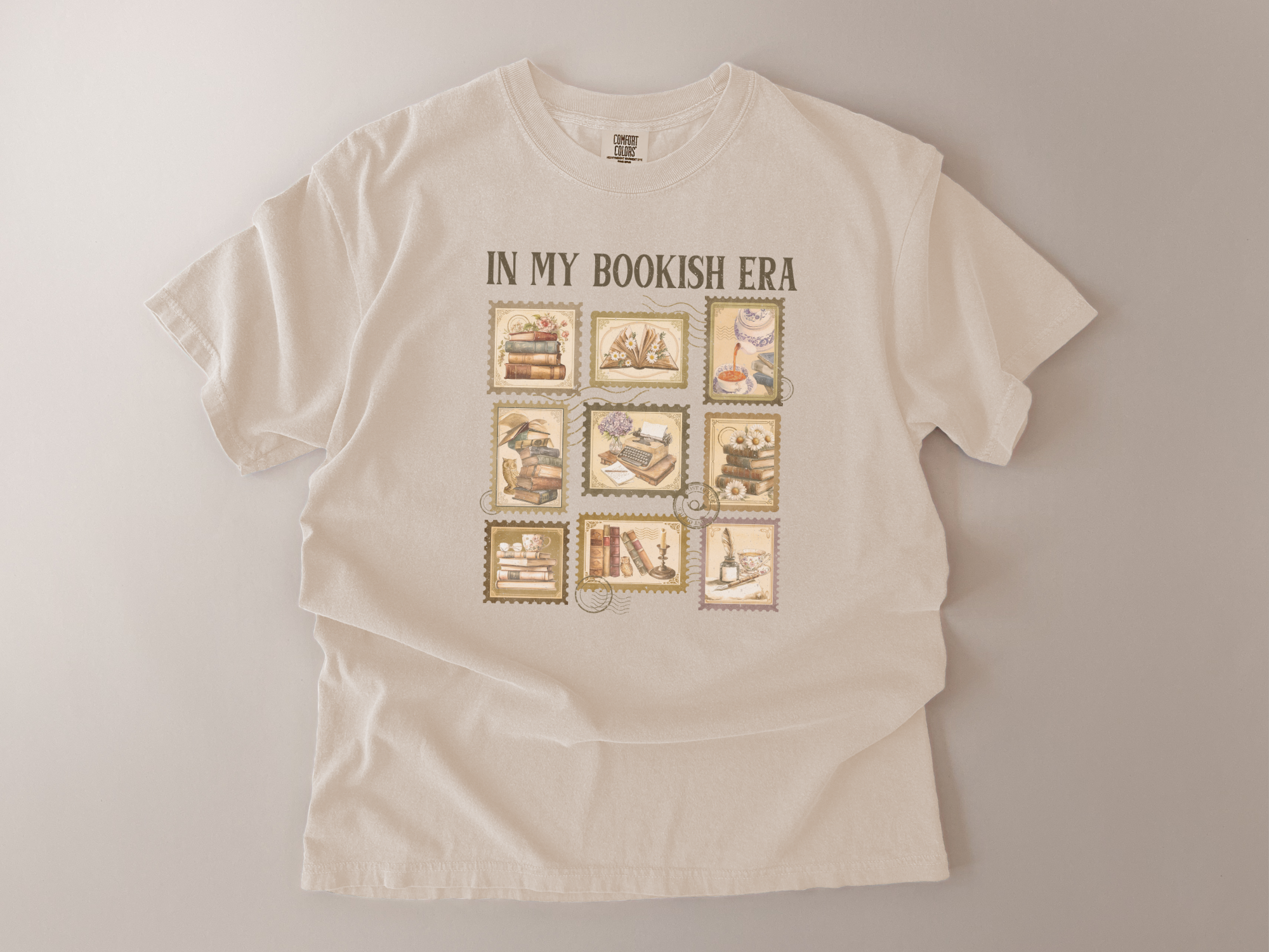 Beige t-shirt with 'In My Bookish Era' text and book-themed graphics on a light gray background