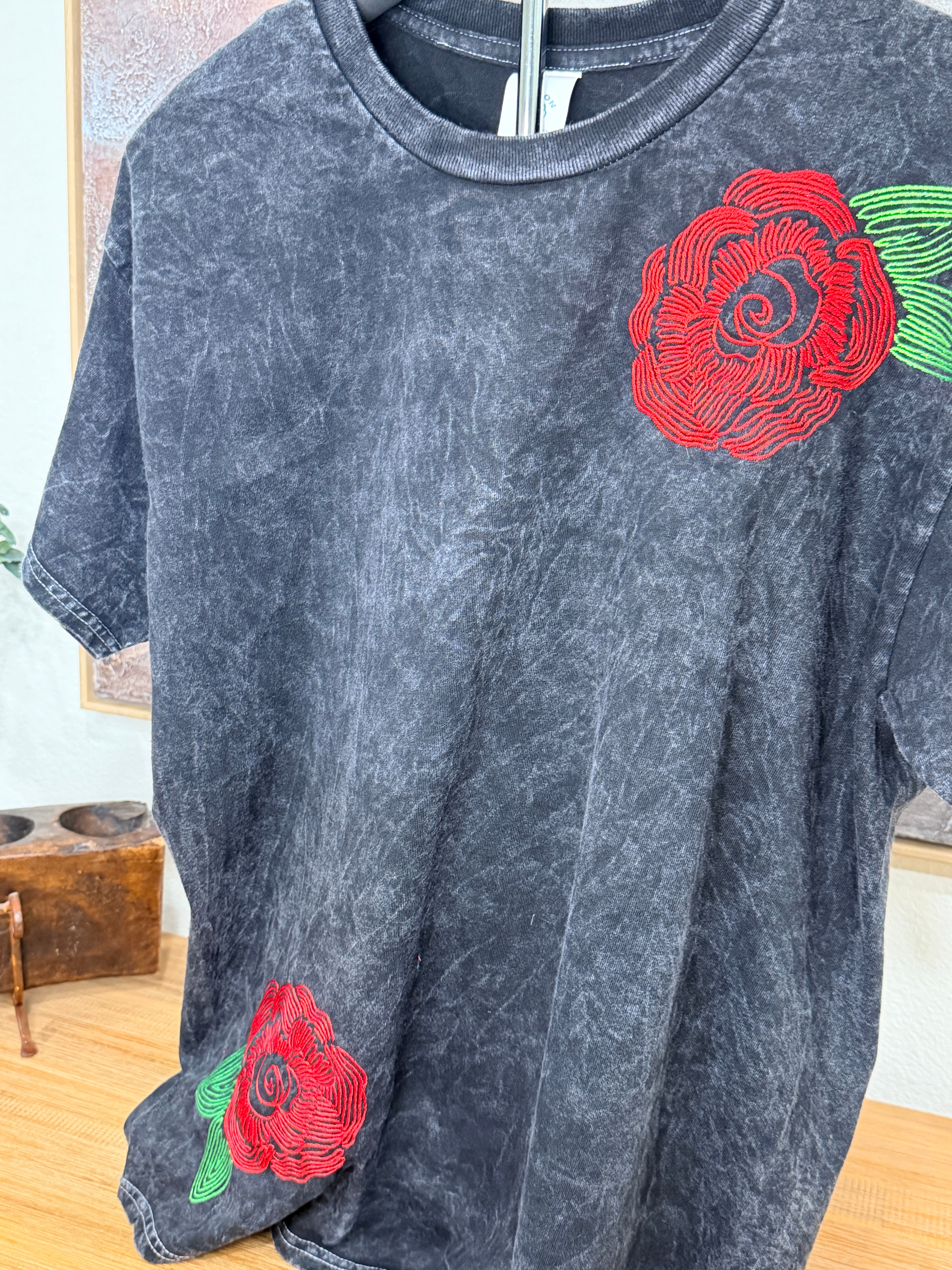 A washed black canvas with story stitched into every detail. The Midnight Bloom Tour Tee is designed to feel like something collected over time—soft, worn, and quietly striking. Three thoughtfully placed embroidery moments create movement across the garment, giving it that imperfect, artful balance that feels both elevated and undone.