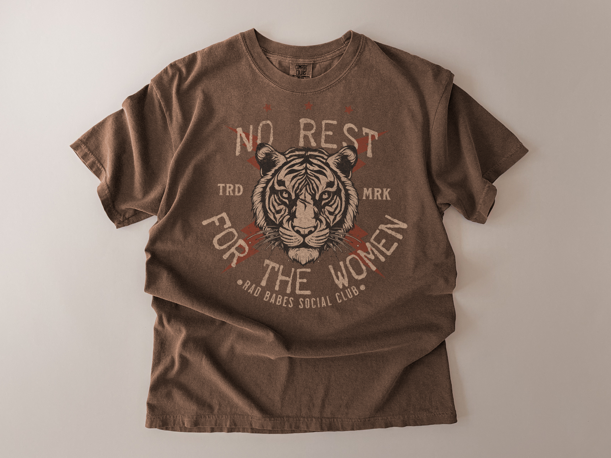 Brown t-shirt with tiger graphic and text on a beige background
