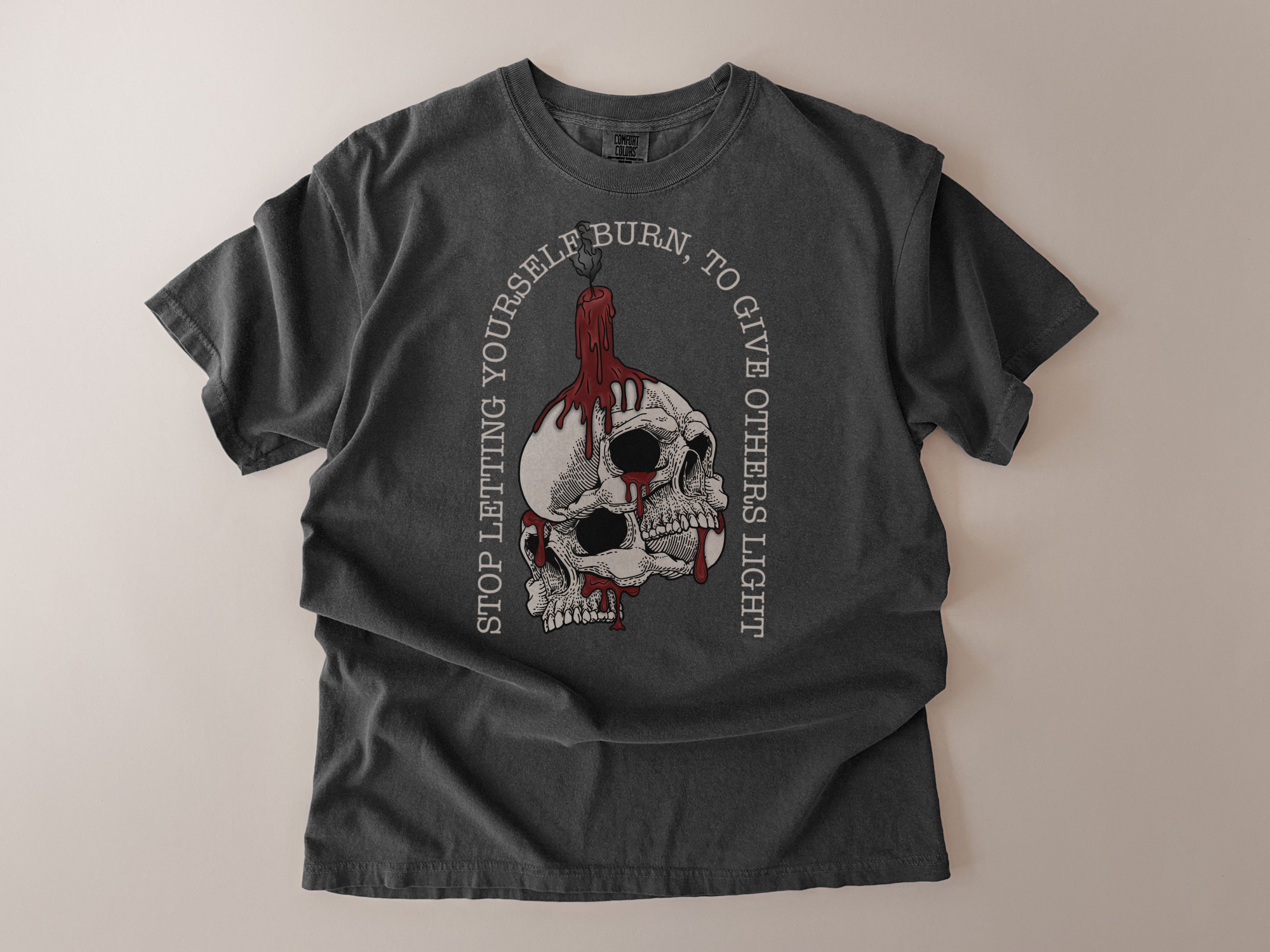 Gray t-shirt with skull design and text on a beige background