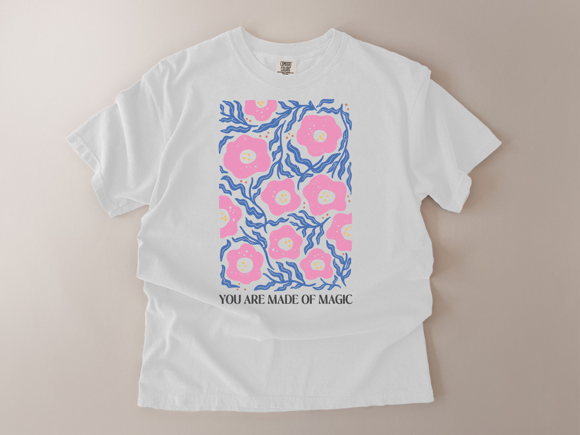 White t-shirt with pink floral design and text on a beige background